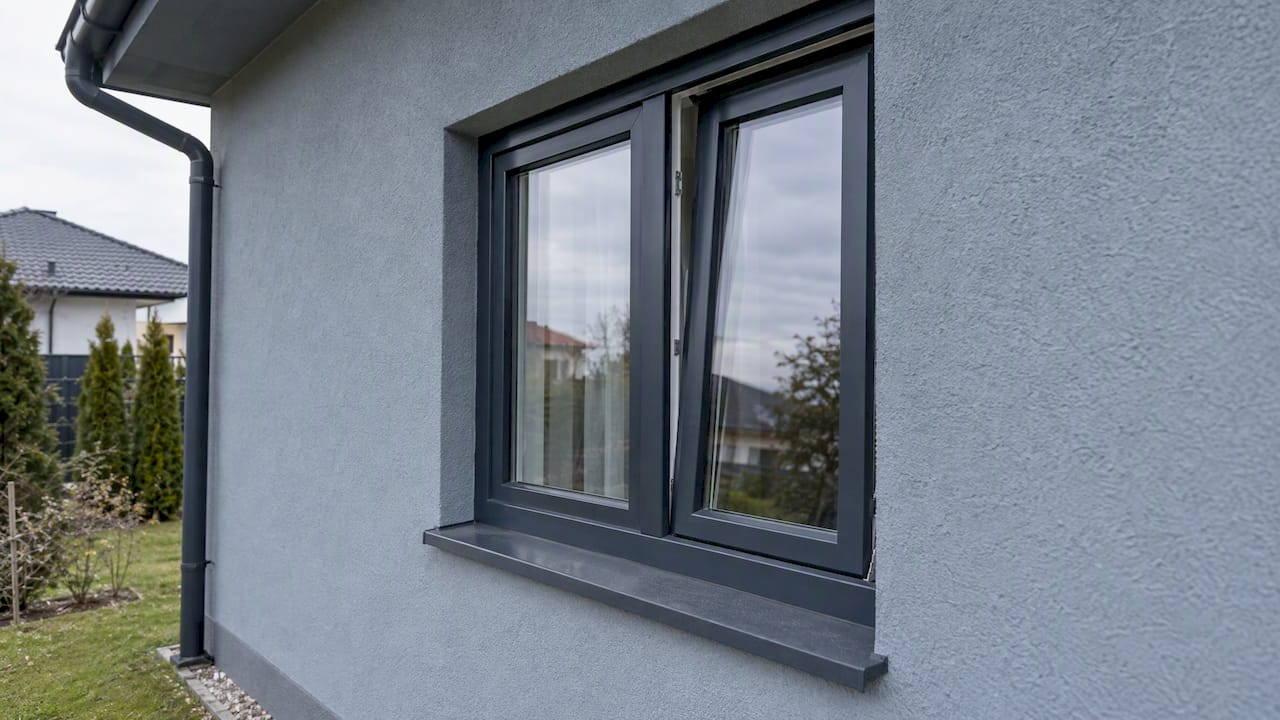 Antracit ablak kékesszürke ház homlokzatán